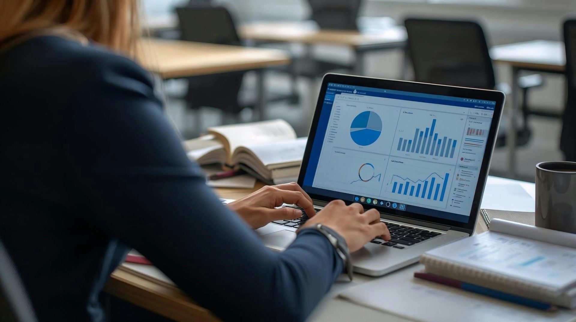 Woman working on laptop with charts and graphs.